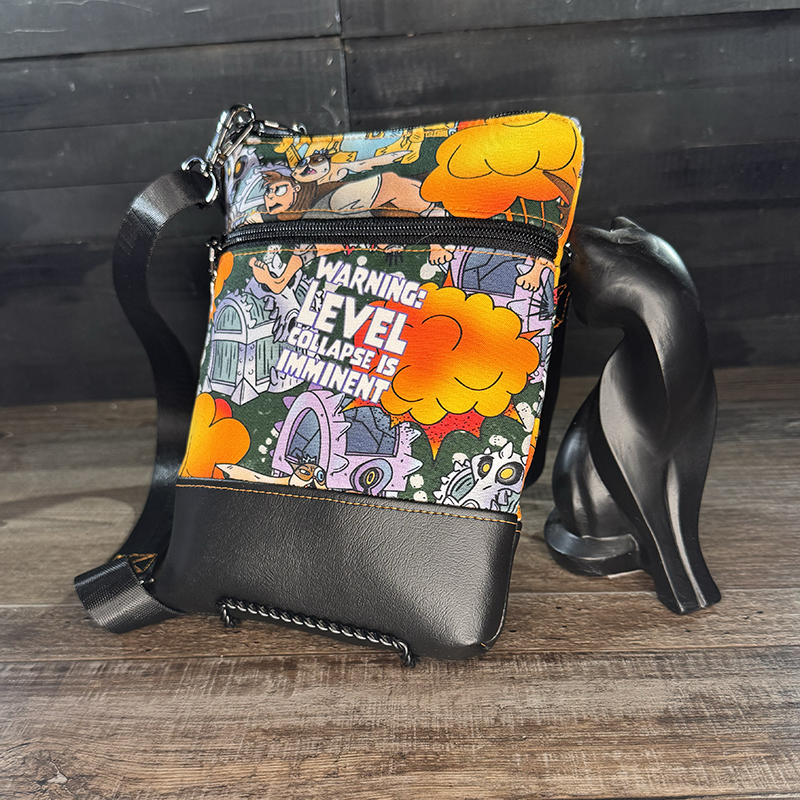 small crossbody phone bag with a cartoon of a man and a cat