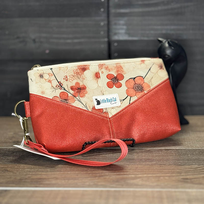 handmade wristlet featuring stylized cherry blossoms on a tan background accented with red sparkle vinyl