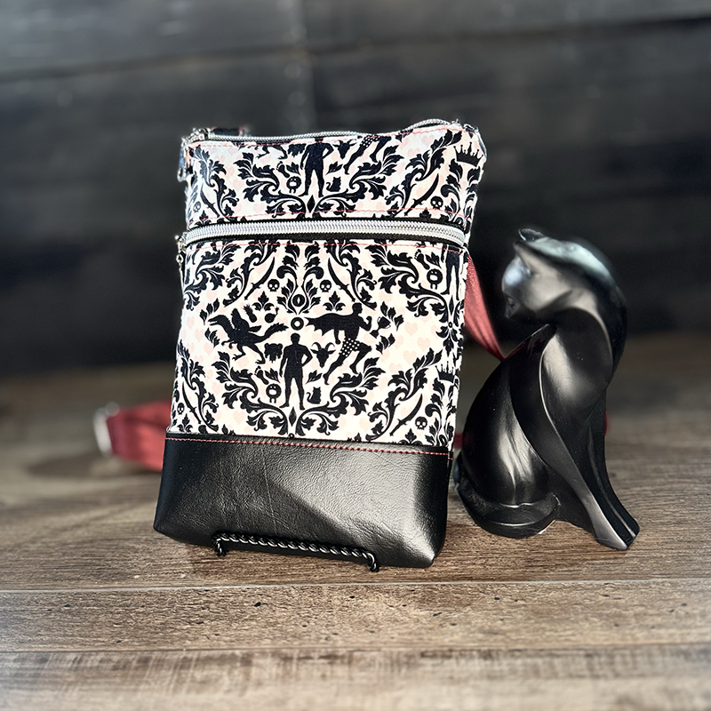 small crossbody phone bag with a cartoon of a man and a cat