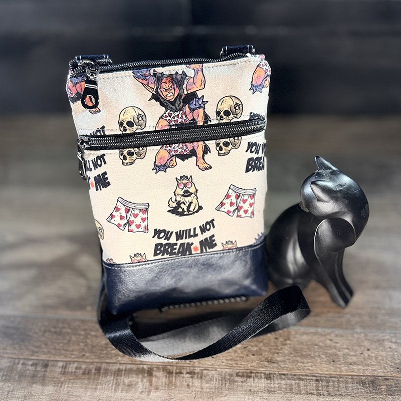 small crossbody phone bag with a cartoon of a man and a cat