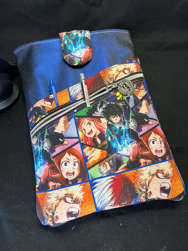 book sleeve with slip and zipper pockets made of shimmery blue vinyl and my hero academia fabric