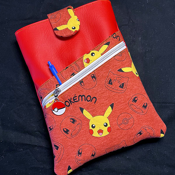 book sleeve with slip and zipper pockets made of red vinyl and pokemon fabric