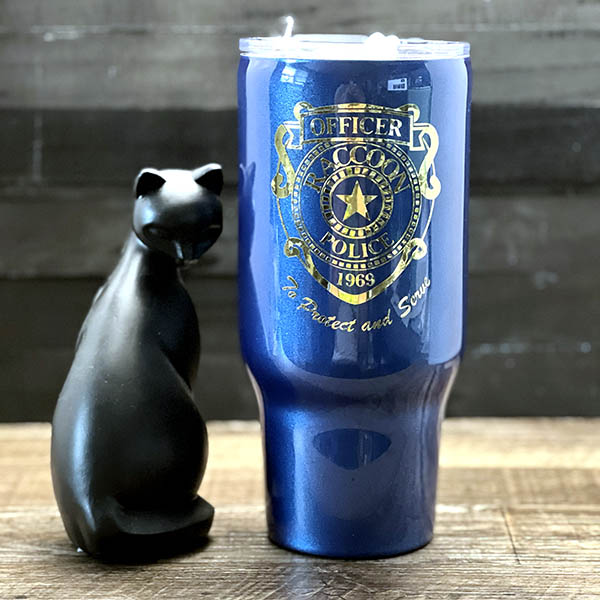 decorated 30oz steel tumbler with blue paint and a gold badge design'