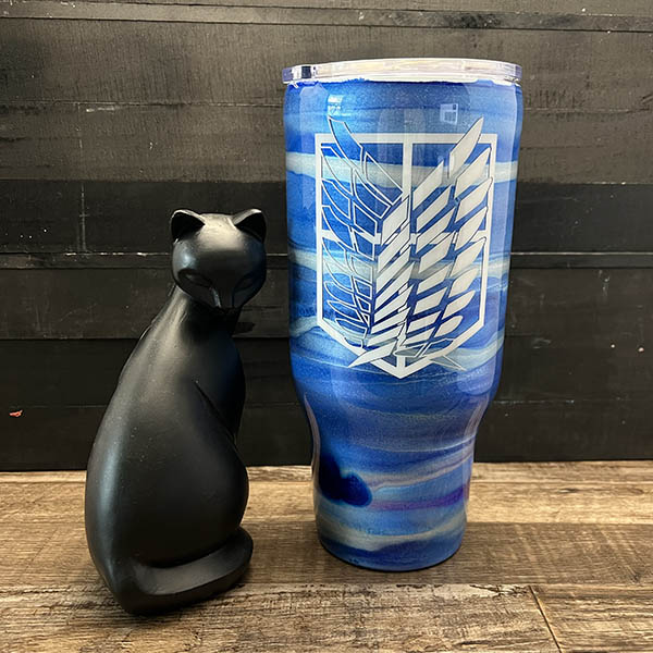 decorated 30oz steel tumbler with blue and silver ink swirls and a vinyl wing design'