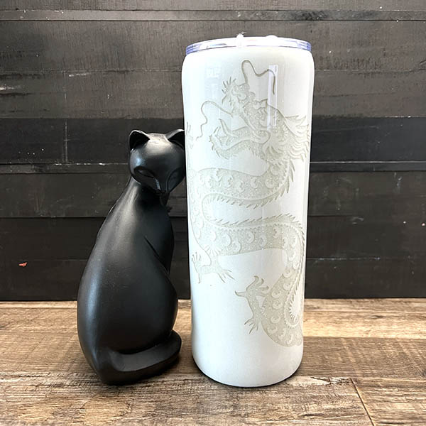 decorated 20oz steel tumbler with a white paint on white glitter dragon design